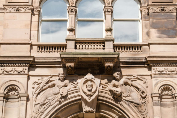 Bust of Henry Harvey and the twin muses on the frontage of the building, Est. 1878.